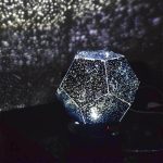 Lysande geodlampa i form av en ikosaeder, som projicerar blinkande stjärnor på väggen, perfekt för vetenskaplig och modern dekoration.