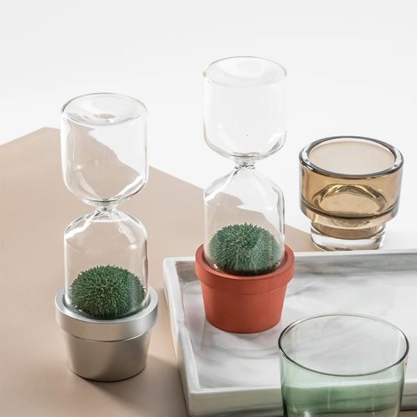 Transparenta glasvaser med suckulenter i keramik- och glaskrukor, moderna dekorationer för hemmet eller kontoret.