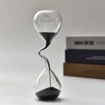Laboratoriesandur i glas med svart sand, symbol för tid och vetenskap, perfekt för kontors- eller hylldekoration, som förenar estetik och vetenskapligt tema.