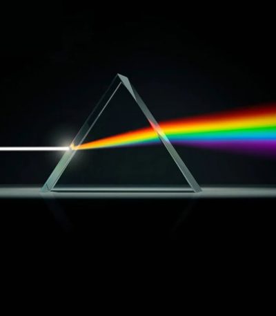 Illustration av ett triangulärt prisma som sprider vitt ljus i ett regnbågsfärgat spektrum, som symboliserar ljusets spridning och optisk vetenskap.
