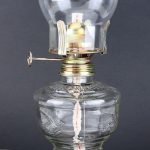 Vintage fotogenlampa i glas med metallmekanism, perfekt för vetenskaplig eller retro inredning.