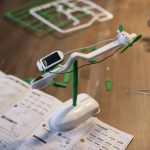 Vetenskaplig experimentbänk med grön propeller, solpanel och vit hållare, används för utbildnings- och experimentella aktiviteter inom vetenskap.