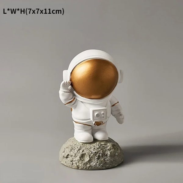 Dekorativ astronautfigur med gyllene hjälm, idealisk för inredning eller som samlarobjekt med rymdtema.