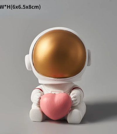 Söt astronautfigur som håller ett rosa plyshhjärta, idealisk för vetenskaplig och lekfull dekoration.