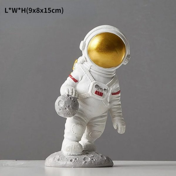Dekorativ astronautfigur i resin, som föreställer en astronaut i vit rymddräkt med gyllene hjälm, idealisk för vetenskaplig eller tematisk dekoration.
