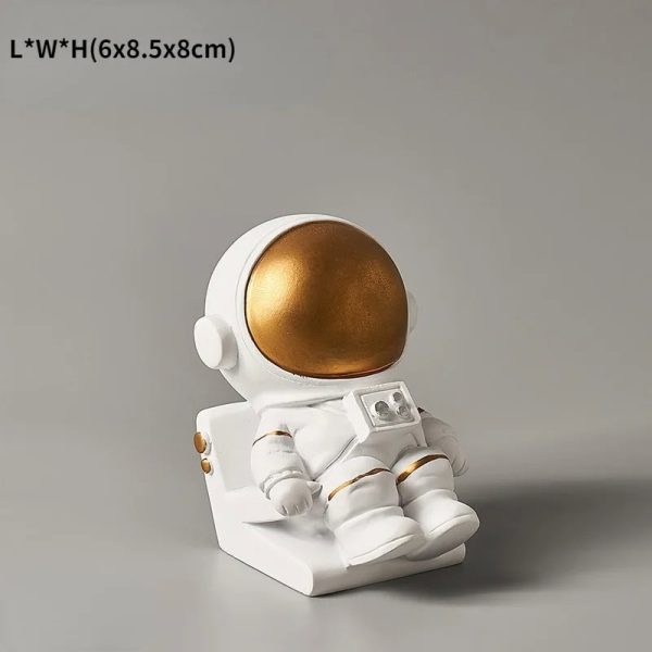 Dekorativ astronautfigur i guld och vitt, idealisk för inredning eller som samlarobjekt med rymdtema.