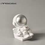 Astronautfigur i vetenskapsdekoration, i vitt med silverhjälm, idealisk för att pryda ett tematiskt utrymme eller en samlarhylla.