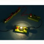 Elektrisk krets med tänd glödlampa och vetenskapliga komponenter.