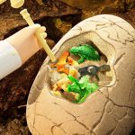 Miniatyr dinosaurieleksak i ett fossiliserat ägg med pipett, perfekt för vetenskaplig eller pedagogisk dekoration.