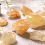 Fynd av kristaller av ädelstenresin i varma nyanser, utställda på en ljus yta, som visar den naturliga skönheten och mineralmångfalden.