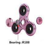 Fidget spinner i rosa metall med kullager, idealisk för avkoppling och koncentration, med ett synligt R188 kullager.