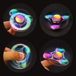 Hänge i glas av en lysande fidget spinner, färgglad och hypnotisk, perfekt för dekoration eller som samlarobjekt.