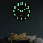 Fluorescerande väggklocka med lysande siffror, visar tiden i nattläge, perfekt för modern och vetenskaplig inredning.