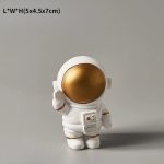 Vas i form av en astronaut med gyllene huvud, idealisk för inredning eller som samlarobjekt.