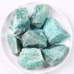 Grupp av råa amazonitstenar, naturlig sten i gröna och blå nyanser, idealisk för dekoration och mineralsamling.