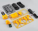 Komponentpanel för utbildningsrobotikset, inklusive motorer, kretskort och gula och svarta plastdelar.