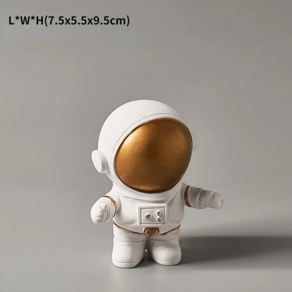 Liten vit astronautfigur i plysch med gyllene hjälm, idealisk för dekoration eller som vetenskaplig present till barn och rymdentusiaster.