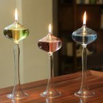 Tre laboratorievaser i glas med färgade vätskor, i brand, på en träyta, som illustrerar ett vetenskapligt experiment eller innovativ dekoration.
