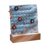 Evig kalender i trä och plast med djur och planeter, idealisk för dekoration av skrivbord eller barnrum, som kombinerar funktionalitet och lekfull design.