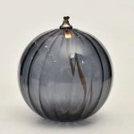 Grå glasvas med svarta ränder, elegant och modern design, perfekt för inredning eller som vetenskapligt samlarobjekt.