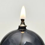 Tänd ljus i en svart glasljusstake, vetenskaplig stil, dekoration för laboratorium eller modern inredning.