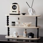 Inredning med en vintage kalender, mineralobjekt och moderna tillbehör på en designhylla, som skapar en sofistikerad och samtida atmosfär.