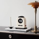 Vintage skrivbordskalender med digital visning, placerad på ett bord med en lampa och tidningar, dekoration inspirerad av vetenskaplig och retro stil.