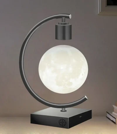 Bordslampa i form av en måne med metallstöd och svart bas.