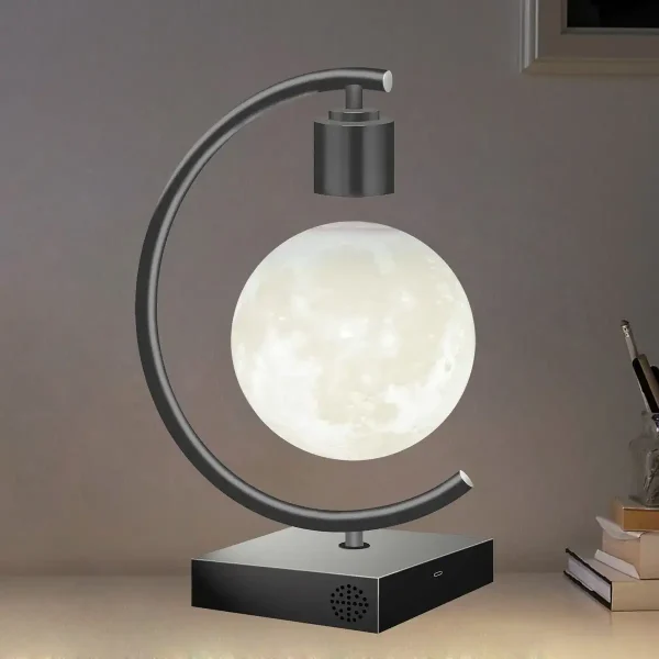 Bordslampa i form av en måne med metallstöd och svart bas.