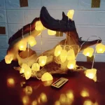 Dekorativ belysning i flytande trä med en girlang av gula LED-lampor, perfekt för en varm och naturlig atmosfär. Idealisk för inredning inomhus eller utomhus.