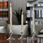 Tre glasljus med tända lågor på ett träbord, elegant och modern dekoration.