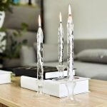 Tre glasljushållare med tända ljus, placerade på ett träbord, elegant och modern dekoration för inredning.