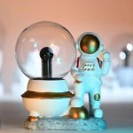 Vitrin med astronautfigur i rymddräkt, placerad bredvid en glasglob, som väcker tankar om rymdutforskning och vetenskap.