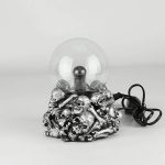Skalle-lampa i metall med genomskinlig glödlampa, original och makaber dekoration för ett unikt inre.