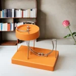 Vetenskaplig pendel i orange med metalliska sfärer, modern och originell dekoration för ett vetenskapligt inspirerat hem.