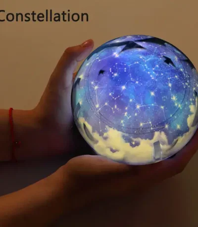 Upplyst kula som föreställer en stjärnkonstellation med en stjärnhimmel och synliga konstellationer, hålls i en hand för en magisk och dekorativ effekt.