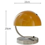 Vintage orange skrivbordslampa med metallbas, elegant och retro design, perfekt för ett kontor eller modern inredning.