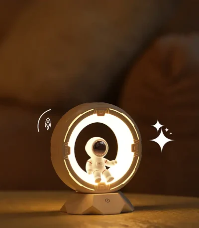 Liten dekoration av ett lysande rymdskepp med en astronaut i vit dräkt, idealisk för en vetenskaplig eller futuristisk atmosfär.