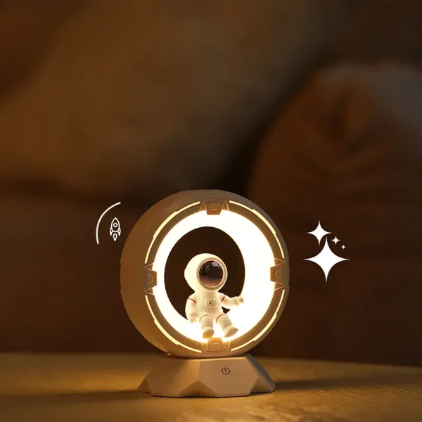 Liten dekoration av ett lysande rymdskepp med en astronaut i vit dräkt, idealisk för en vetenskaplig eller futuristisk atmosfär.