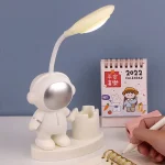 Original skrivbordslampa som föreställer en astronaut med en flexibel lampa, idealisk för kontors- eller rumsinredning.