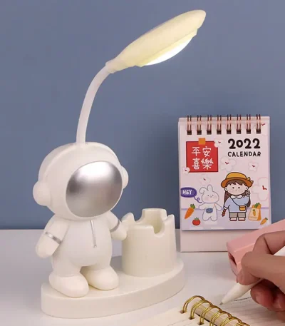 Original skrivbordslampa som föreställer en astronaut med en flexibel lampa, idealisk för kontors- eller rumsinredning.