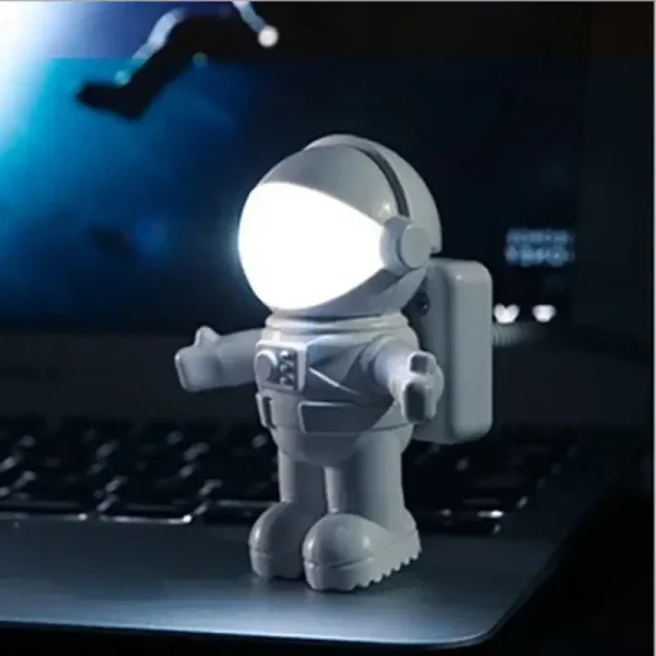 Liten astronautfigur i plast med inbyggd LED-lampa, idealisk för kontors- eller vetenskaplig temadekor, som ger en futuristisk och lekfull touch.
