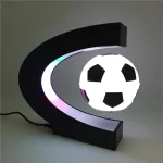 Skrivbordslampa i C-form med en LED-fotboll, idealisk för kontors- eller barnrumsdekoration, som ger en sportig och modern touch.