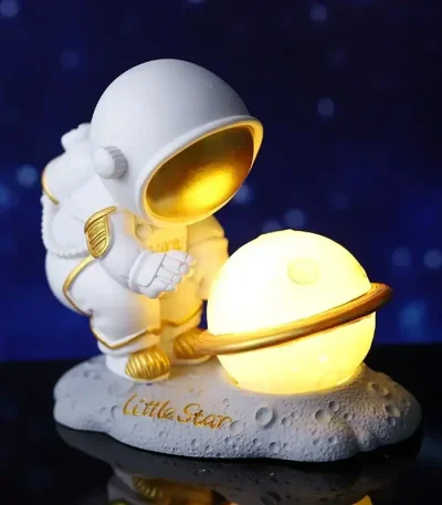 Astronautfigur med lysande planet, rymdtema dekoration för hemmet eller kontoret.