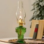 Dekorativ oljelampa i grönt glas med tänd låga, perfekt för vetenskaplig eller vintage dekoration.