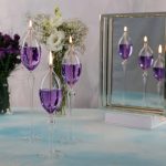 Ljus i form av lågor i transparenta glasbehållare med lila vätska.