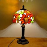 Tiffany-lampa i färgglatt glas med blommönster, som ger en konstnärlig och varm touch till din inredning.