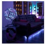 Modern geometrisk LED-lampa med färgglad belysning i ett samtida vardagsrum.