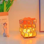 En dekorativ lampa i orange glas, inspirerad av ett vetenskapligt tema, avger ett varmt ljus, perfekt för en mysig atmosfär eller en originaldekoration.