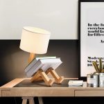 Original skrivbordslampa i form av en robot i trä med tygskärm, perfekt för modern och lekfull dekoration i ett arbetsutrymme eller rum.